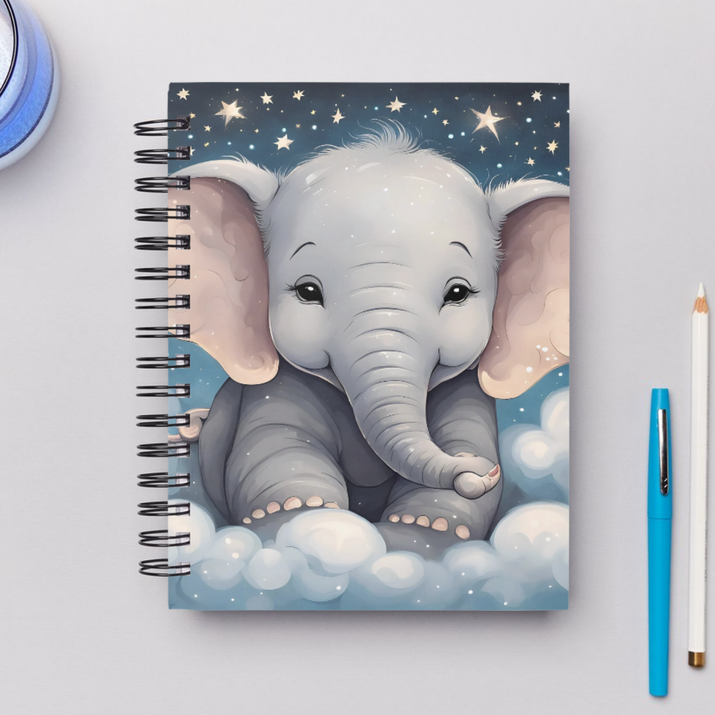 Cute baby elephant illustration with dreamy clouds and stars on a whimsical notebook