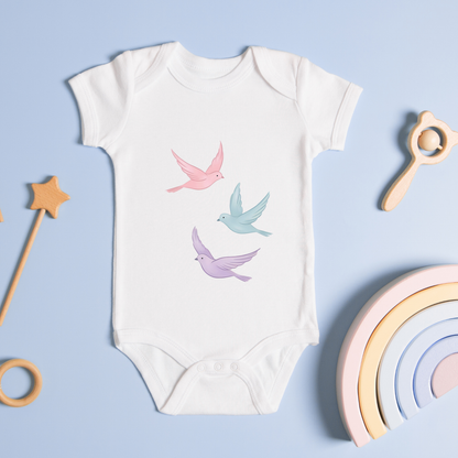 Baby clothes with an illustration of flying birds in soft pastel tones, representing freedom and peace